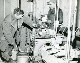 Two Men Working on Machinery
