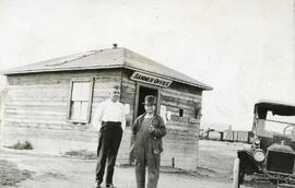 Two Men in Front of A "Banner Office"