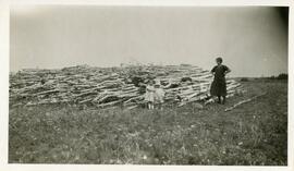 A Woman and Two Children in Front of A Wood Pile Near Biggar, Saskatchewan
