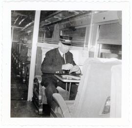 Conductor L.C. Minshall checking tickets