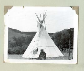 Woman sitting in front of tipi