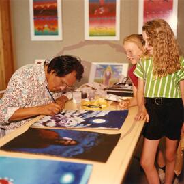 Artist Dennis Smokeyday demonstrating his painting technique for young visitors