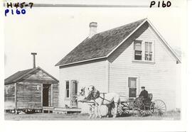 Farm House with two horse team and buckboard.