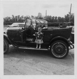 Child on running board of antique car