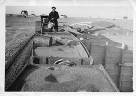 Man standing in a grain wagon or "tank"