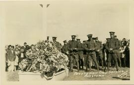 Soldiers with heads bowed at memorial for war dead