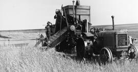 Combine and tractor harvesting wheat