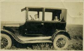 Boy and dog in early car (1926)