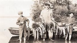Man and Two Children Holding Line With Caught Fish