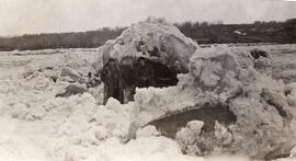 Two Men Standing in Front of a Large Chunk of ice