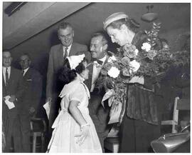 A woman receiving flowers at an election meeting