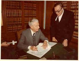 John Diefenbaker signing a book in the House of Commons