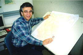 Prof. Lawrence Martz checks a map in a Geography Dept. lab