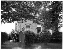 John Diefenbaker standing in front of the brick house in Neustadt, Ontario