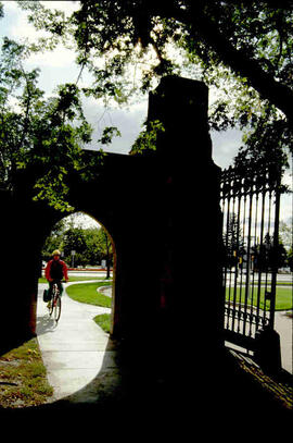 Student cycling in through memorial gate