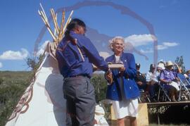 Cy Standing and Peggy McKercher jointly holding land deed at opening ceremonies