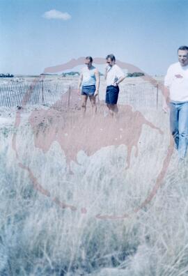 Dr. Ernie G. Walker and two others standing in field