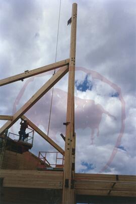 Beam being anchored in place by person on man lift