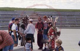 Visitors speaking with dancers in traditional regalia