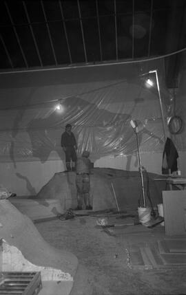 Two people constructing elements of exhibition